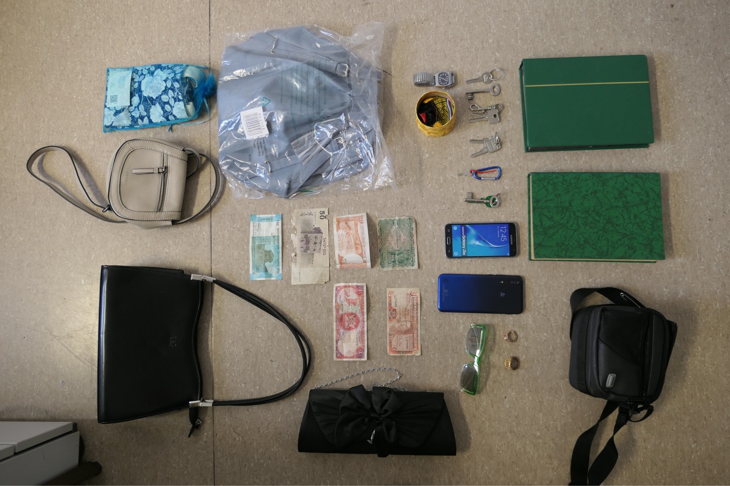 Diese mutmaßlichen Beutestücke konnte die Polizei nicht zuordnen: Zwei grüne Briefmarkenalben, mehrere Handtaschen und Schlüssel, eine Armbanduhr, zwei Handys und Geldscheine in verschiedenen Währunge