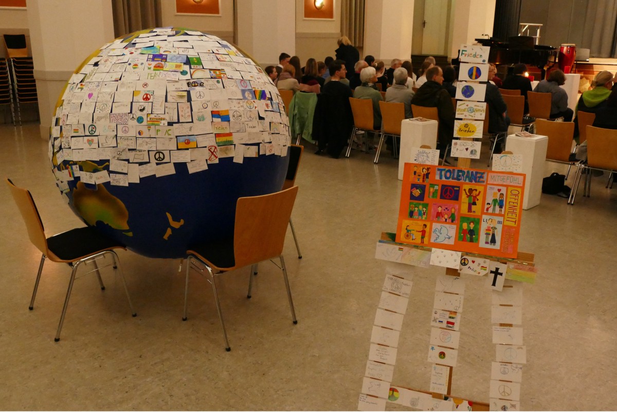  Lesung12: Die von Schülerinnen und Schülern der Projektgruppe ‚Humanitäre Schule‘ gestaltete Weltkugel mit Friedensbotschaften setzte ein klares Zeichen gegen Gewalt und Krieg. 